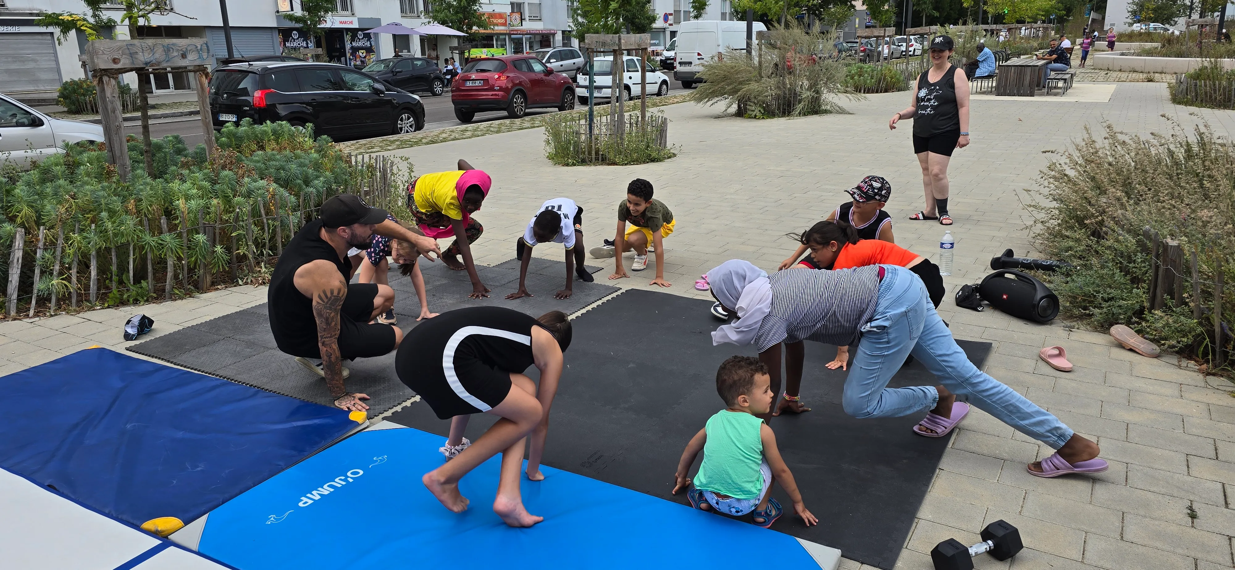 Initiation au breaking en extérieur avec des enfants sur des tapis, dans le cadre de Quartiers d'été à Dijon