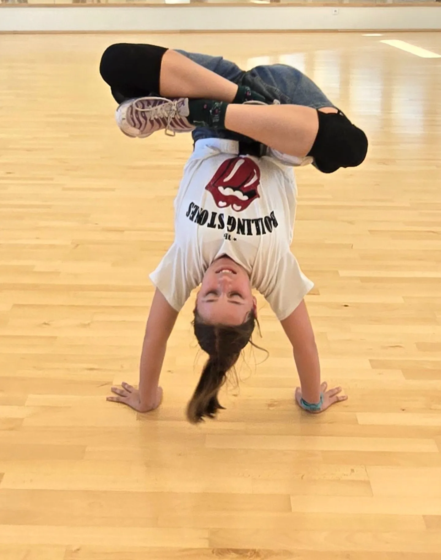 Danseuse HDMI Team en figure de breaking (appui renversé au sol) dans un studio d'entraînement